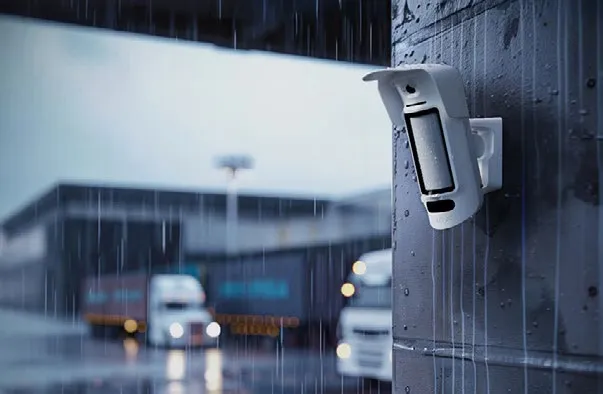 Wetterfester Ajax-Außenbewegungsmelder mit Fotokamera an einer Hauswand im Regen